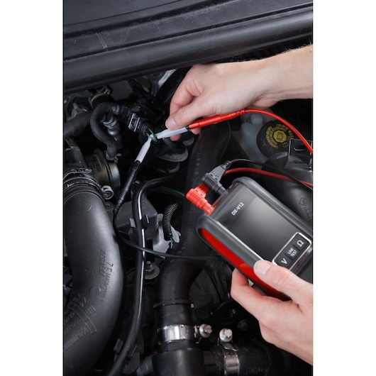 Photo of Facom DX.V12PB automotive diagnostic tool in use checking car engine wiring.