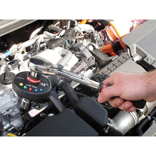 Photo of Facom E506-200S torque wrench used to tighten a bolt in a car engine compartment.