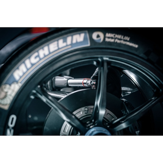 Facom E_516ST-135PB torque wrench used on a motorcycle wheel, close-up showing detailed tool application.