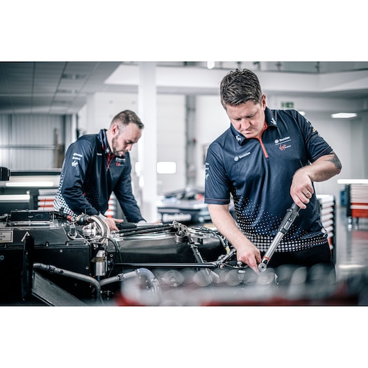 Facom E_516ST-135PB photography of technicians using torque wrenches on automotive assembly in workshop.
