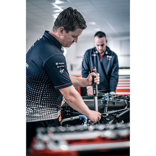 Facom E_516ST-135PB torque wrench being used on machinery by a technician in a workshop setting.