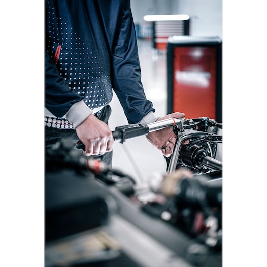 Facom E_516ST-30PB torque wrench used on engine part in workshop, product close-up photography.