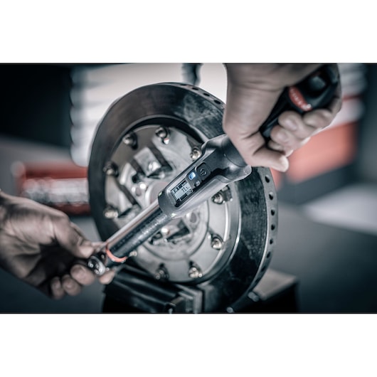 Facom digital torque wrench E_516ST-30PB in use tightening bolts on a brake disc.