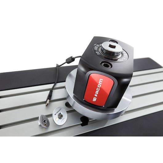 Facom E_6000-C400 electronic torque tester on metal surface, USB cable and accessories visible, angled view.