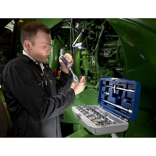 Facom E032900 socket set used by technician near green machinery, open case showing sockets and tools.