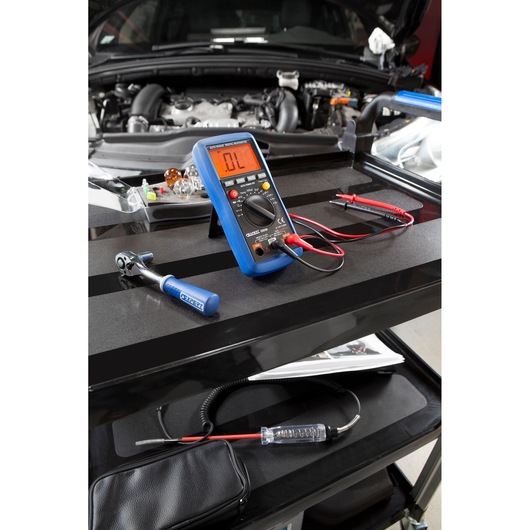 Facom E051301 digital multimeter on tool cart with tester probes, automotive repair setting.