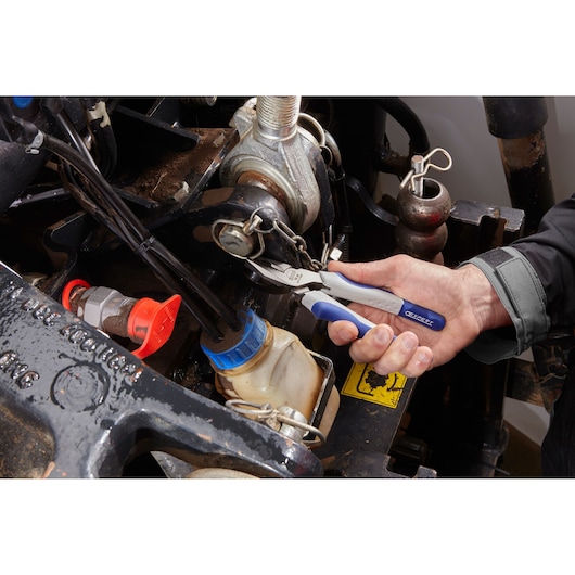 Facom E080505 diagonal cutting pliers with blue and white handles used on machinery by a person.