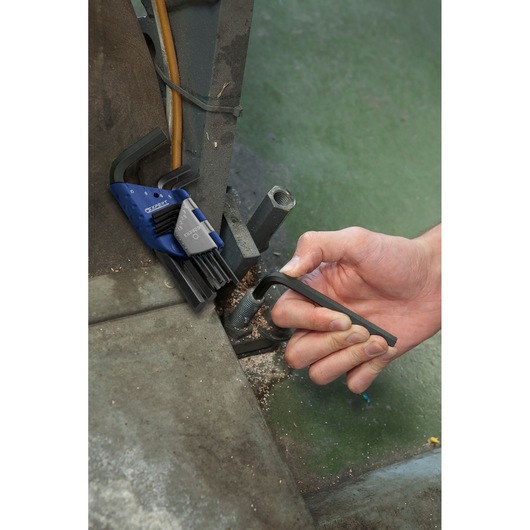 Facom E113929 hex key set in use on industrial machinery, close-up view showing hand turning hex key.