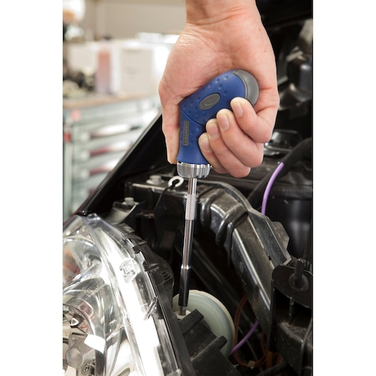 Facom E160802 screwdriver with blue handle being used to tighten screw in car engine compartment.
