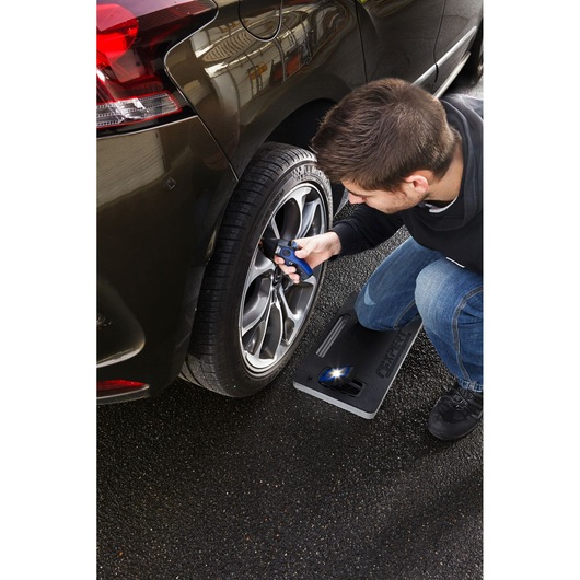 Facom E201120 kneeling mat in use beside a car wheel, with person checking tire pressure.