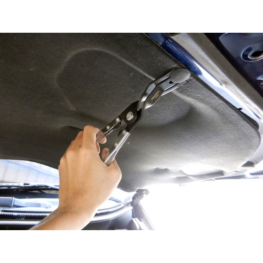 Facom E201201 automotive trim pliers used under a car hood for removing panel fasteners.