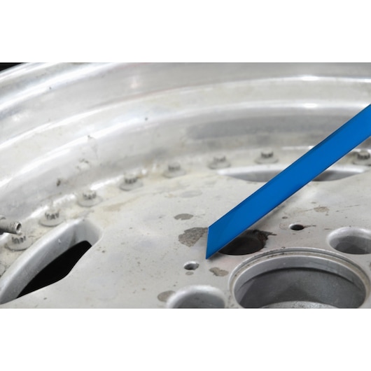 Facom E201204 blue lever tool on metallic wheel hub, close-up shot.