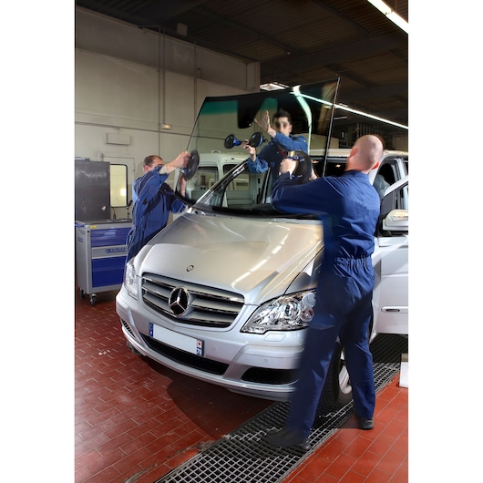 Facom E201502 photography of technicians installing windshield on silver car in workshop.
