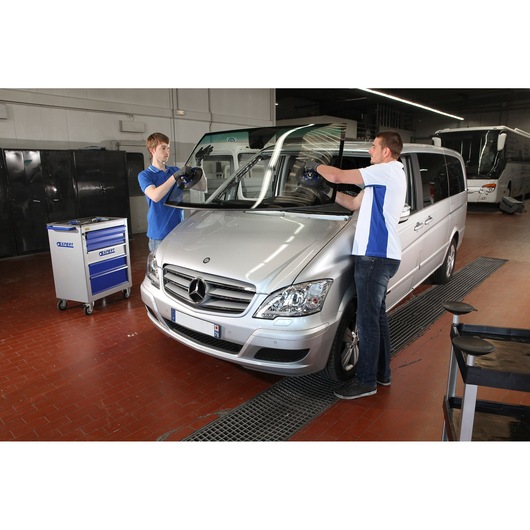 Facom E201504 photography of technicians replacing windshield on silver Mercedes van in workshop.