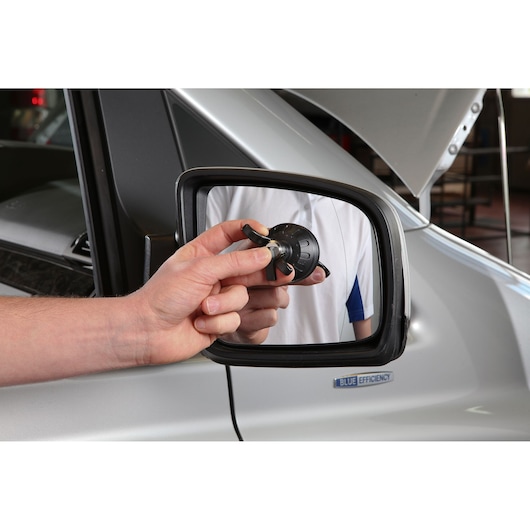 Facom E201508 tool held by hand in front of car side mirror, photography category.