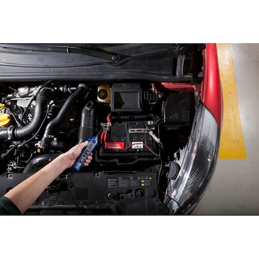 Facom E201806 automotive diagnostic tool used on a car battery, close-up photography.