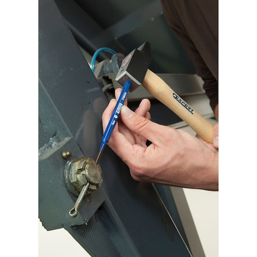 Facom E418234 blue metal punch tool in use with hammer on machinery part.