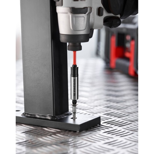 Photo of Facom EN_1J30PB screwdriver bit holder in use with drill driving screw into metal base.