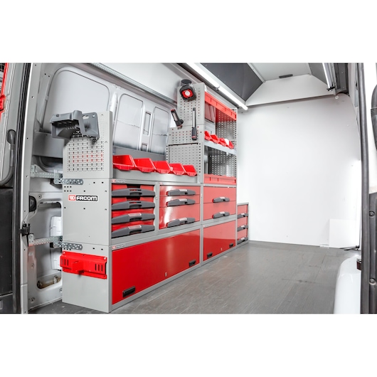 A view of a Facom-branded modular storage system with red and grey drawers, shelves, tool bins, and organizers installed inside a van workspace.