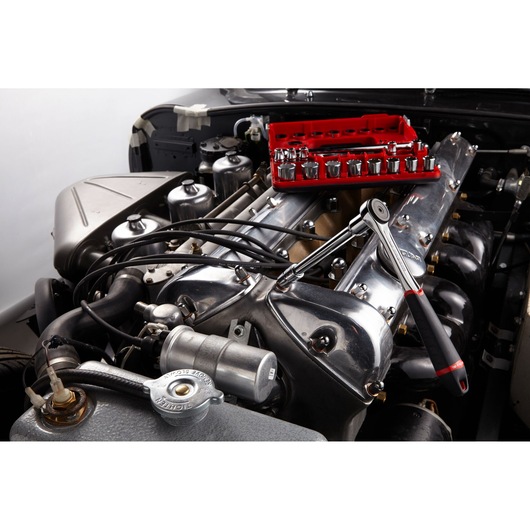 Facom J_161DBOX1 ratchet and socket set displayed on car engine, photography category, side angle.