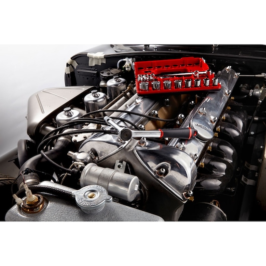 Facom J_161DBOX1 socket set and ratchet on car engine, photography showing tools in use.