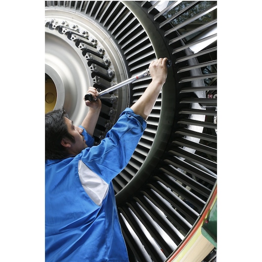 Facom J306A100 torque wrench used by technician on turbine assembly, close-up photography.