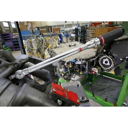 Facom J306A50 torque wrench with black grip shown in use on machinery in an industrial workshop setting.