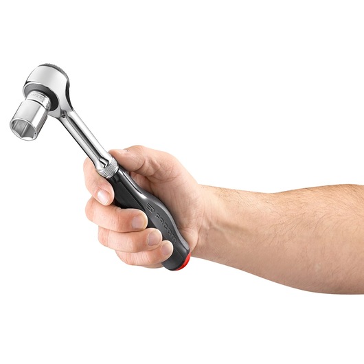 Photo of Facom J_360 ratchet wrench with socket, held in a hand, side view on white background.