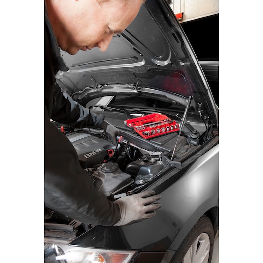 Facom red socket set JXL_171 in use during car engine maintenance, photography with mechanic and open hood.