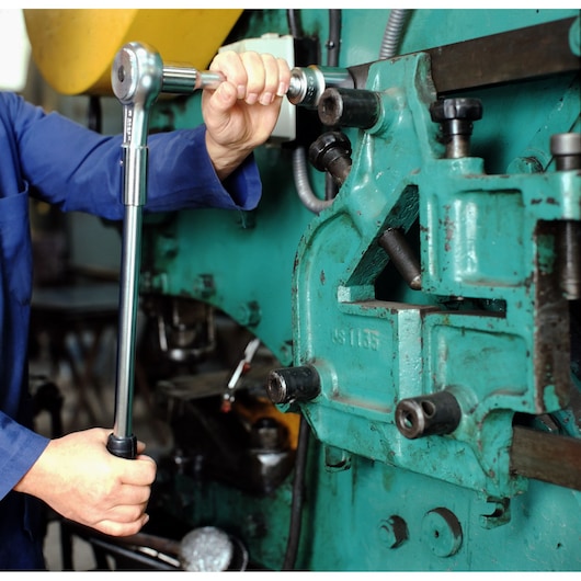 Facom K_210B torque wrench used by technician on industrial machinery, close-up photography.