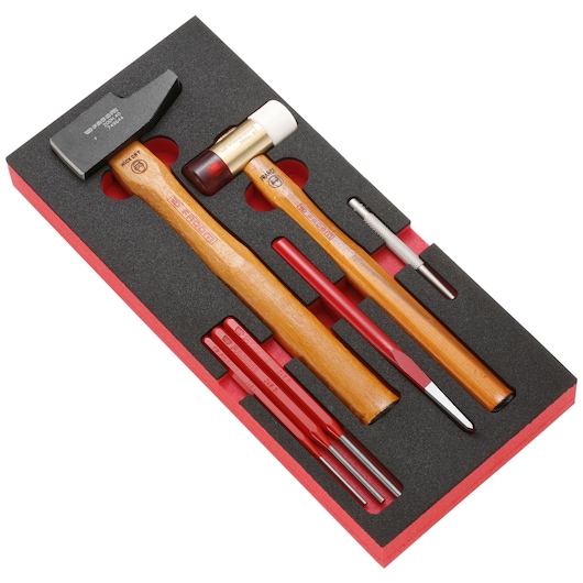 Facom MODMMI1 hand tool set with two hammers, punches, and chisels in black foam tray, angled view.