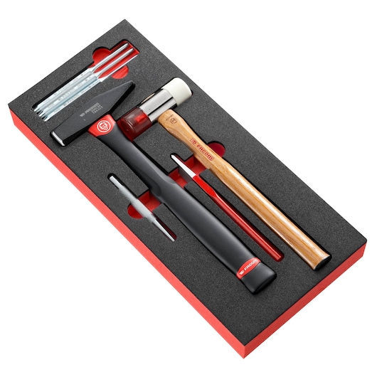 Facom MODM_MI7 tool set with hammers, punches, and chisels in black foam tray, top angle on white background.