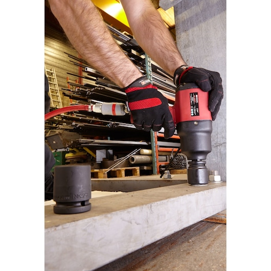 Facom impact socket NK.2000F2PB in use with power tool and gloved hands, industrial workspace background.