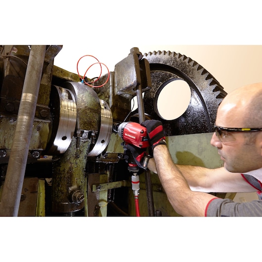 Facom NK.3000FPB pneumatic impact wrench used on industrial machinery, worker wearing gloves.
