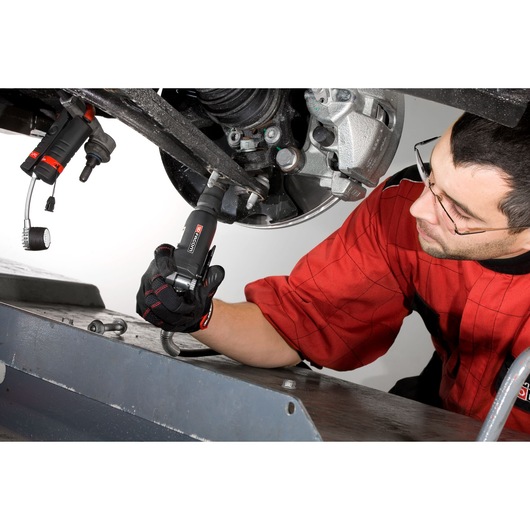 Facom NS.1400FPB photography of mechanic using Facom tool on vehicle suspension system.