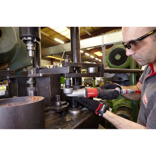 Photo of Facom NS_A1700F2 pneumatic angle wrench in use on industrial machinery by a gloved technician.