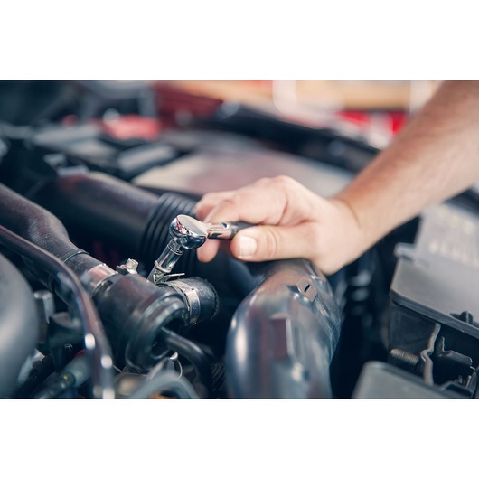 Photo of Facom R_181 ratchet wrench in use on car engine, close-up view