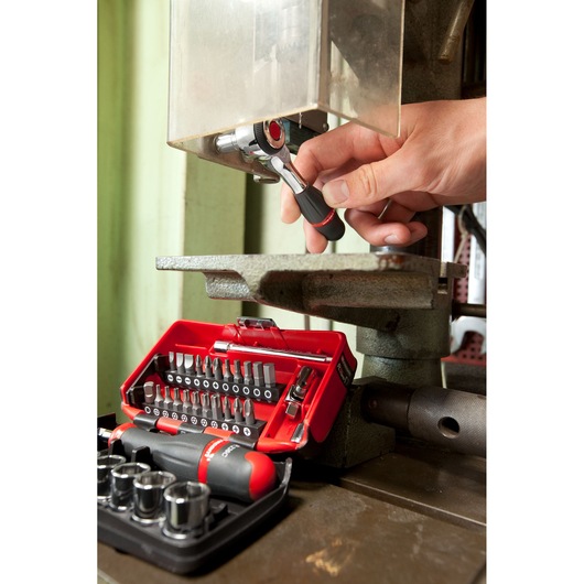 Facom R_360NANO compact ratchet and bit set in use, red tool case with assorted bits and sockets.
