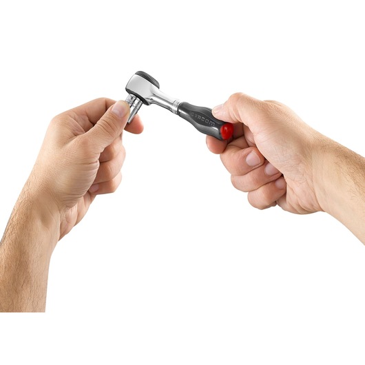 Photo of Facom R_360 ratchet wrench with black handle held in two hands, white background, product side view.