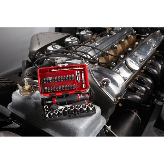 Facom R2NANO compact socket and bit set displayed on a car engine, photography of tool kit in use.