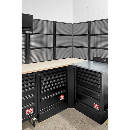 Photo of Facom RWS2-CSWBS corner workshop unit with black metal drawer cabinets, wood and metal countertops, pegboard panels.