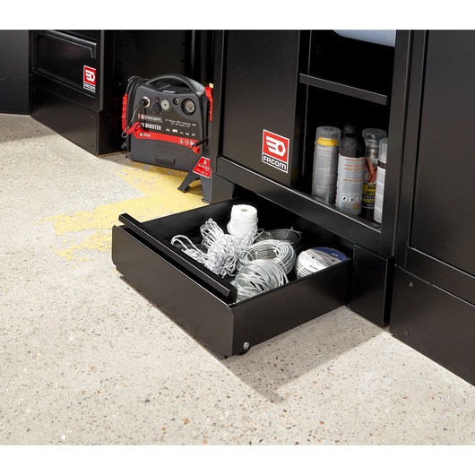 Facom RWS2-DRAWERBS black steel storage drawer open with coiled cords and rope inside, next to cabinets on workshop floor.