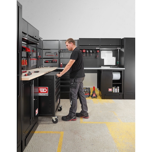 Facom RWS2-ROLL6M3ABS black rolling tool cabinet in workshop, side angle, surrounded by storage units.