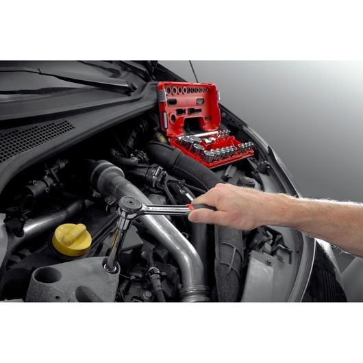 Facom S_161B ratchet and socket set in use on car engine, red case open, automotive tool photography.