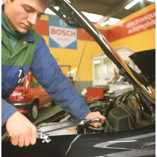 Facom S_203DA photography of mechanic using wrench on car engine in workshop.