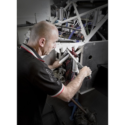 Facom S_209-340PB torque wrench used by technician on automotive chassis in workshop.