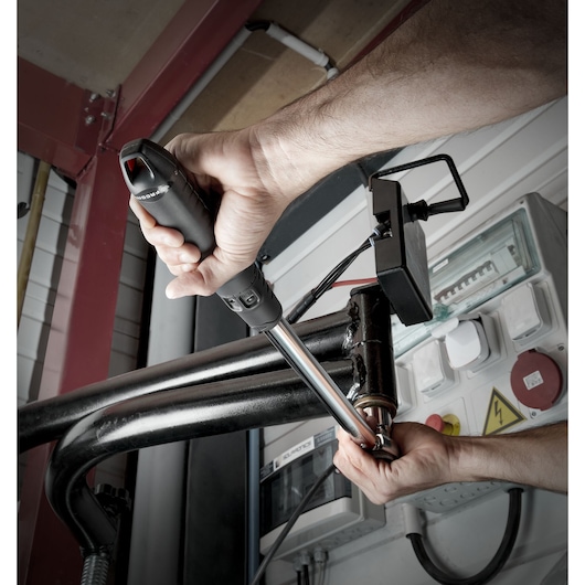 Photo of Facom S_209-340PB torque wrench being used to tighten a bolt on a metal pipe in an industrial setting.