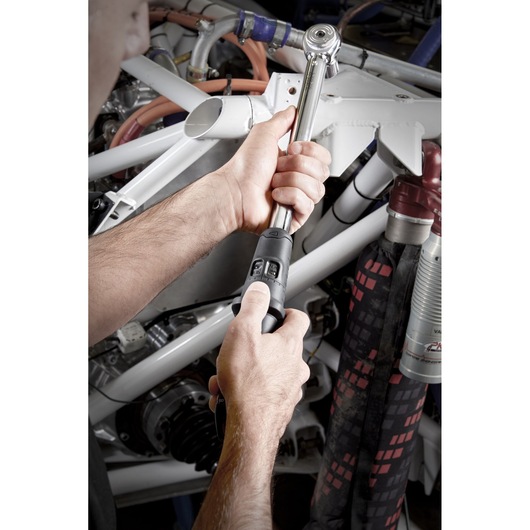 Facom S.209A200 torque wrench in use near automotive parts, close-up photography.