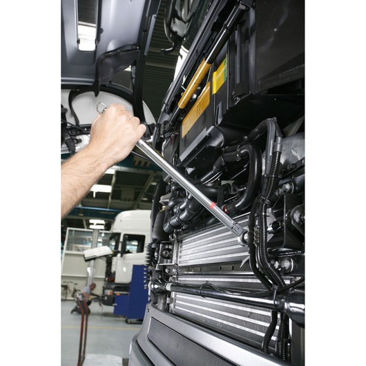 Facom S_248-200D torque wrench used on engine components in a workshop setting.