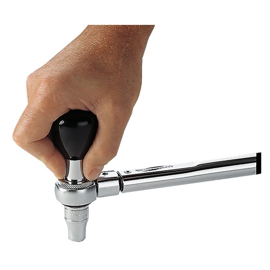 Facom S_305P ratchet wrench with black handle held in hand, close-up on white background.